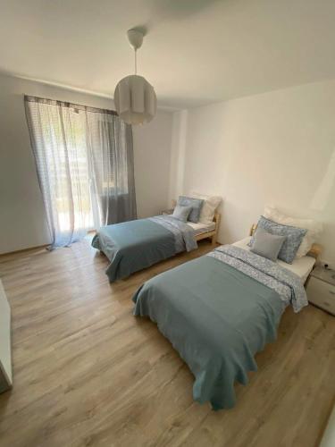 een slaapkamer met 2 bedden en een groot raam bij Öcsi Vendégház in Balatonlelle