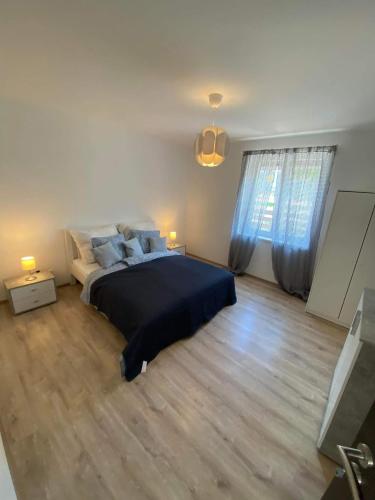 een slaapkamer met een groot bed en blauwe gordijnen bij Öcsi Vendégház in Balatonlelle