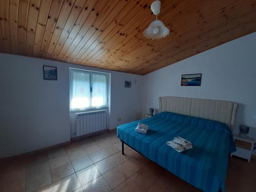a bedroom with a bed and a wooden ceiling at La casa di Amelia in Borzonasca