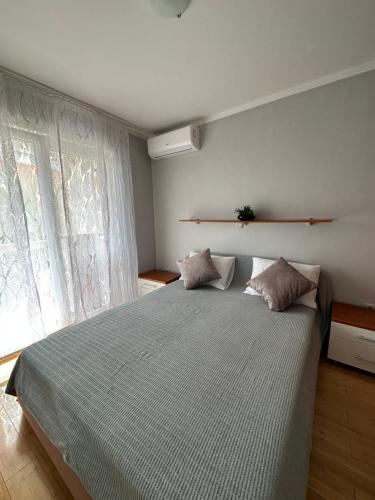 een slaapkamer met een groot bed en een raam bij Apartments Roxsi in Novalja