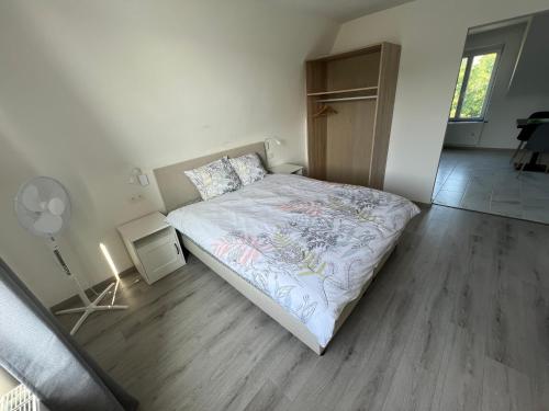 a small bedroom with a bed and a fan at Riverbank Guest House in Namur