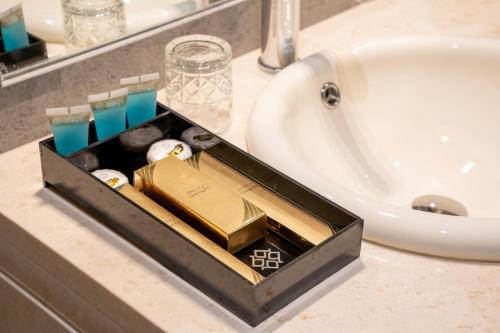 ein Tablett auf einer Badezimmertheke neben einem Waschbecken in der Unterkunft مستقر للشقق الفندقية الياسمين in Ha'il