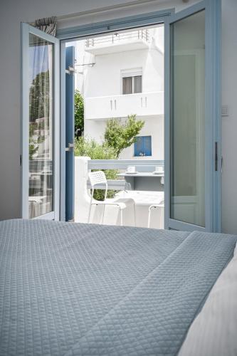 a bedroom with a bed and sliding glass doors at Hotel Iris in Naousa