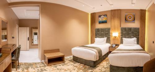 a hotel room with two beds and a television at Mostagr Serviced Apartments - Yasmine in Hail