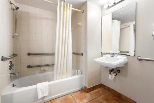a bathroom with a sink and a bath tub and a toilet at Tidelands Caribbean Boardwalk Hotel and Suites in Ocean City