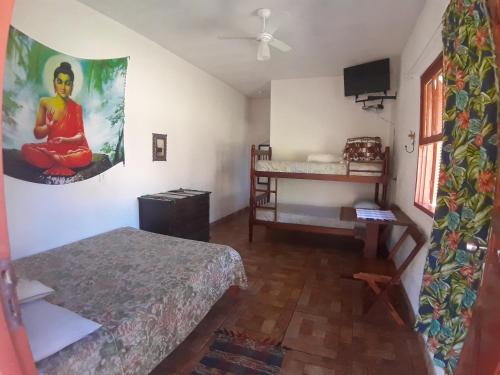 a room with two beds and a ceiling fan at Pousada Natureza in São Thomé das Letras