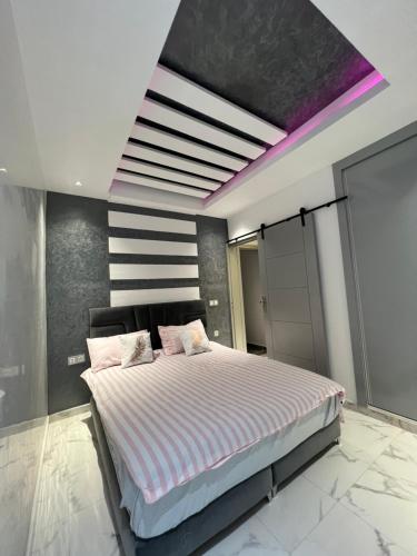 a bedroom with a large bed with a purple ceiling at Appartement moderne avec Hammam en plein centre ville in Agadir