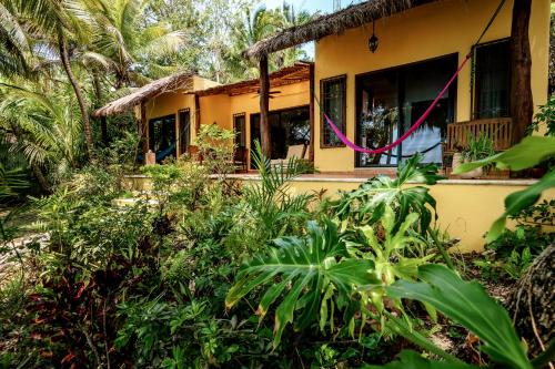 a house in the jungle with trees and plants at Hotel Rancho Encantado in Bacalar