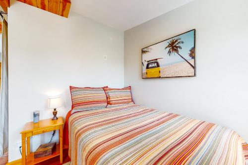 een slaapkamer met een bed en een foto van een palmboom bij West Side Cottage in Boise