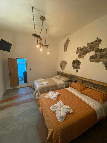 1 dormitorio con 2 camas y un mapa en la pared en El Acicate Hospedaje, en Cuetzalán del Progreso