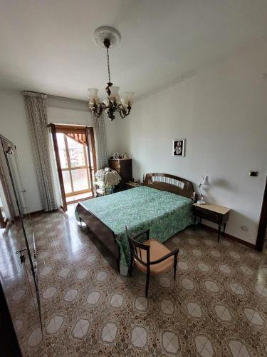 a bedroom with a green bed and a chandelier at Avellino casa centralissima in Avellino