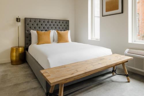 a bedroom with a large bed and a wooden bench at Sonder The Artesian in Denver