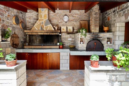 an outdoor kitchen with a brick wall and a fireplace at GK - Modern Apartment in Nafpaktos