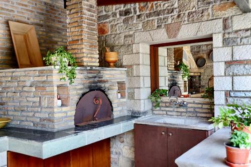 uma cozinha com uma parede de tijolos e um forno de pedra em GK - Modern Apartment em Lepanto