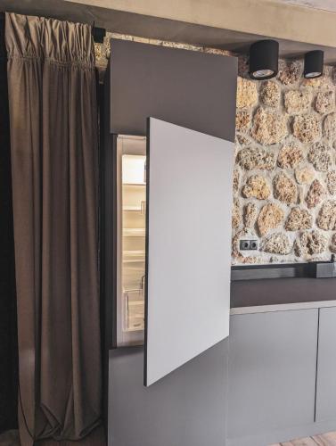 a kitchen with an open refrigerator and a window at Three Dots Boutique Suites in Soúlion