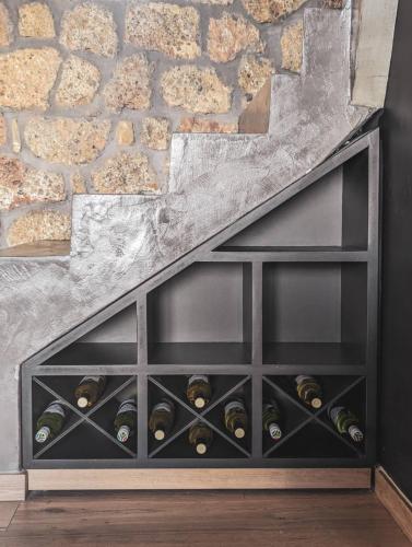 a wine cellar with wine bottles in a stone wall at Three Dots Boutique Suites in Soúlion