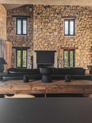 a living room with a stone wall and a fireplace at Three Dots Boutique Suites in Soúlion