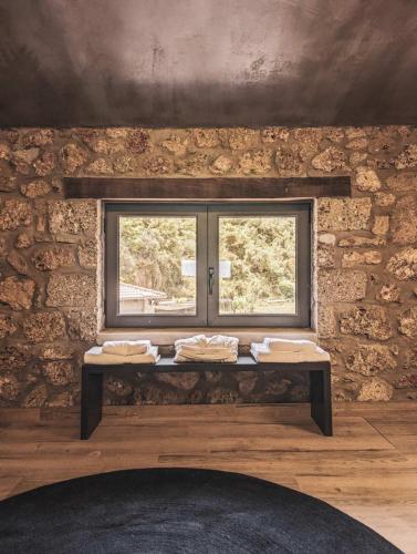 a window in a brick wall with a table in front at Three Dots Boutique Suites in Soúlion
