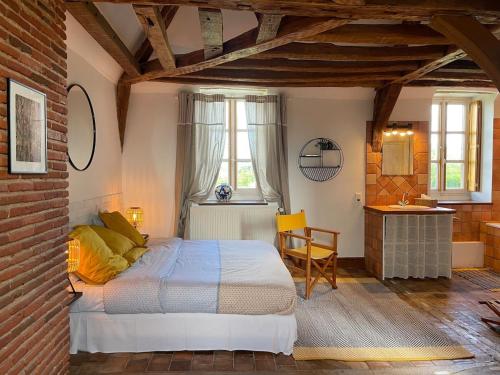 a bedroom with a bed and a table and a chair at Maison de Famille près de Montargis - Élégance et Confort en Forêt - FR-1-590-354 in Paucourt