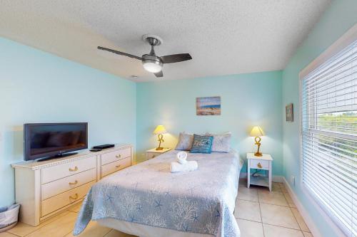 a bedroom with a bed and a flat screen tv at Highland Avenue Heaven in Bradenton Beach