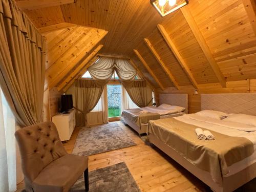 a room with two beds and a chair in it at Bali Mountain resort Montenegro in Bijelo Polje