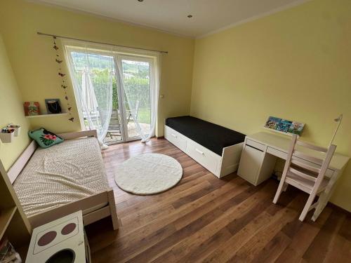 a bedroom with a bed and a desk and a window at Živa Blatnica in Blatnica