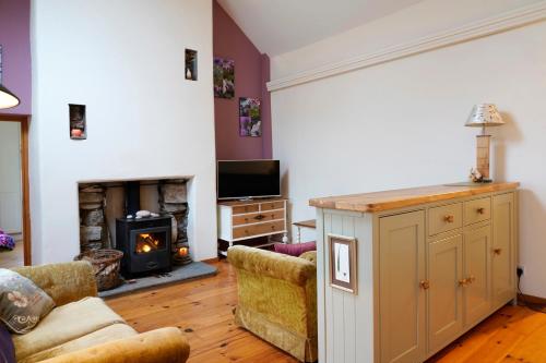 a living room with a couch and a fireplace at Meadow Cottage in Belmullet