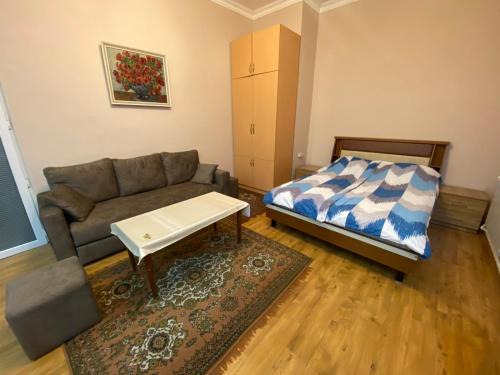 a living room with a couch and a bed at Studio apartment in Yerevan in Yerevan