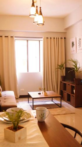 a living room with a table and a large window at Manila Airport Staycation near NAIA Terminal 3 in Manila