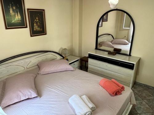 a bedroom with a white bed with a large mirror at Vila Katerina Anna in Nea Kalikratia