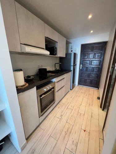 a kitchen with a wooden floor and a wooden door at Studio Epoustouflant Vue Mer St Martin in Cul de Sac