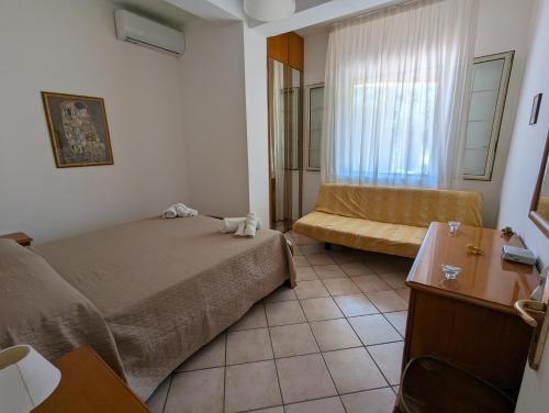 a small bedroom with a bed and a couch at Villa Valeria in Floridia