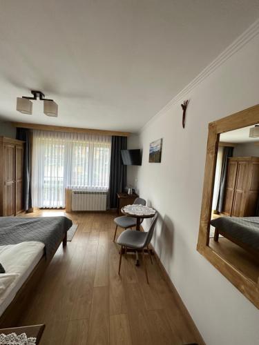 um quarto com uma cama, uma mesa e um espelho em Willa Mango em Zakopane