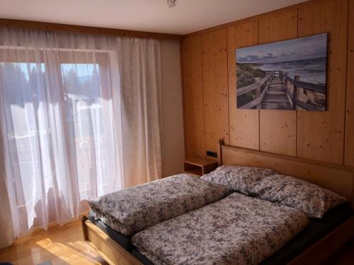 a bedroom with a bed and a large window at Haus Gruber in Feldkirchen in Kärnten