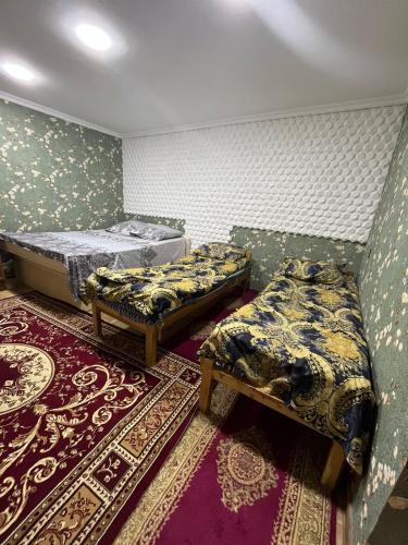 a room with two beds and a rug at Дом для отпуска у моря in Artyom