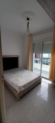 1 dormitorio con cama y ventana grande en Dar lbhar, en Kelibia
