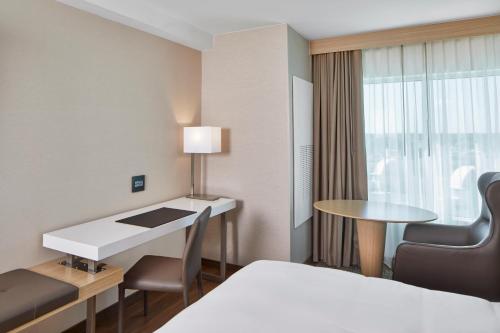 een hotelkamer met een bed, een bureau en een tafel bij AC Hotel by Marriott Orlando Lake Buena Vista in Orlando