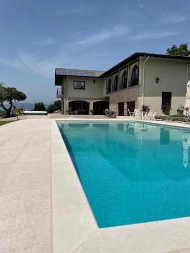 a large blue swimming pool in front of a house at Heart House Franciacorta in Erbusco