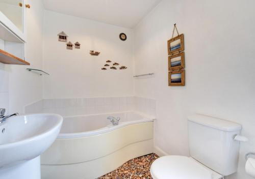 a white bathroom with a tub and a toilet at Avalon in Aldeburgh