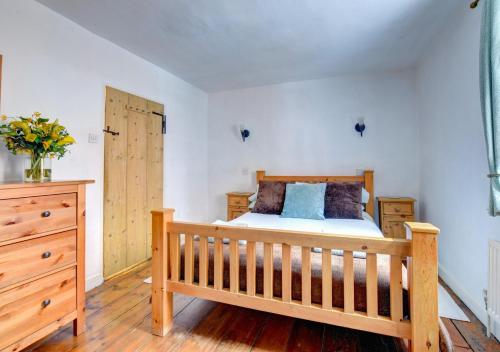 a bedroom with a wooden bed and a wooden dresser at Avalon in Aldeburgh