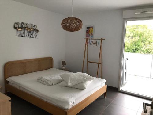 une chambre avec un lit avec des draps blancs et une fenêtre dans l'établissement Appartement à Nice, à Nice