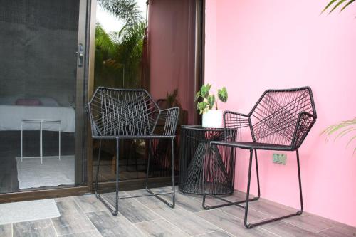 dos sillas y una mesa junto a una pared rosa en Hotel Daleese en Uvita