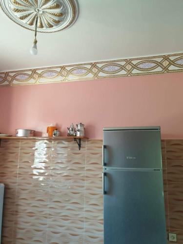 a green refrigerator in a kitchen with pink walls at Dar rachid ouzoud in Azilal