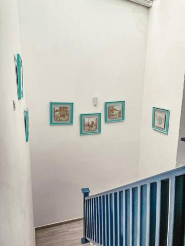 a white wall with three framed pictures on it at ALWADI Chalet - Khorfakkan in Khor Fakkan