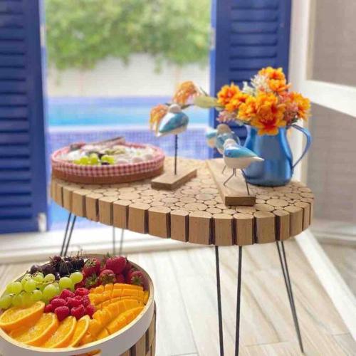 two plates of fruit on a table with birds on top at ALWADI Chalet - Khorfakkan in Khor Fakkan