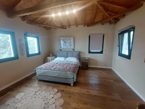 a bedroom with a bed in a room with wooden floors at Luxury Villa in Sklithri in Skiathos Town