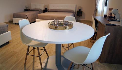 - une table et des chaises blanches dans une chambre dans l'établissement B&B I Greci, à Vairano Patenora