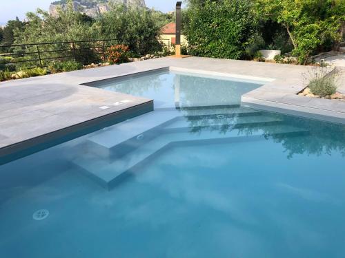 a swimming pool with blue water in a yard at Casa Miraflores in Cefalù