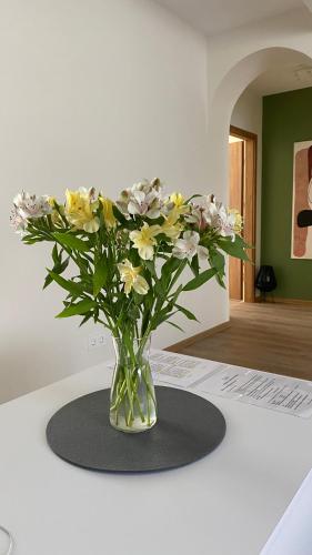 a vase filled with flowers sitting on a table at Japandi apartamentai in Kaunas