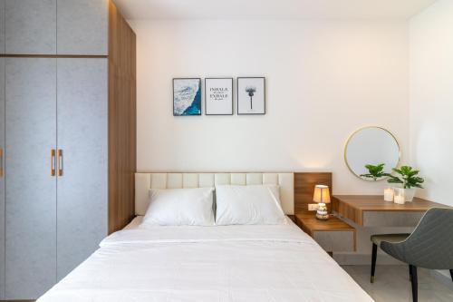 una camera con letto bianco e scrivania di New Luxury 2BR Apt - Terra Royal Ho Chi Minh City ad Ho Chi Minh